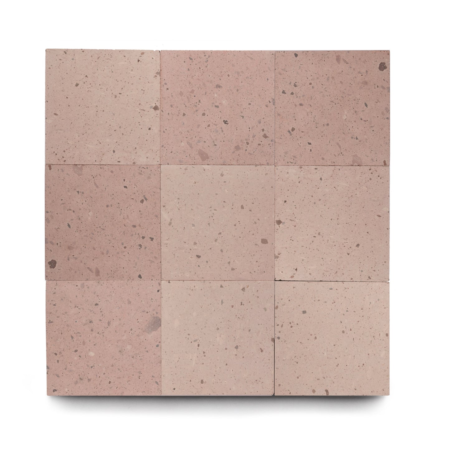 Nine Yuma 12x12 tiles by Zia Tile, in muted pink and beige, are arranged in a three-by-three grid, each displaying unique texture and subtle speckling inspired by natural volcanic stone.