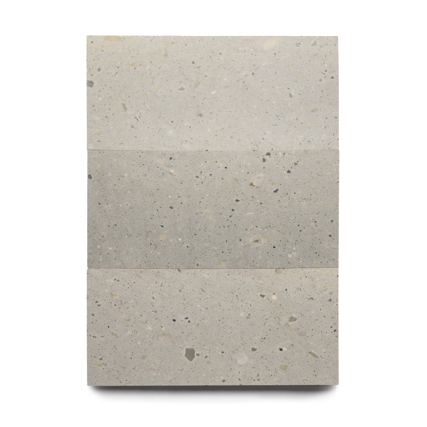 Three Acacia 12x24 tiles by Zia Tile, featuring speckled gray-beige surfaces and unique natural volcanic stone textures, are stacked vertically against a white background. Each tile displays slight shade variations.