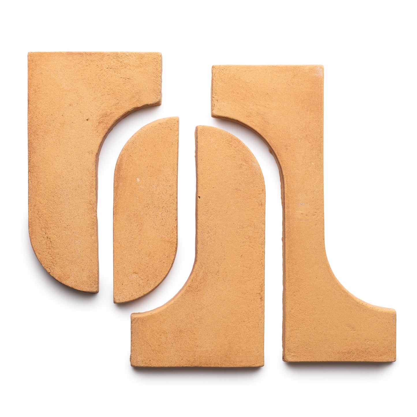 Four Durango + Adobe tiles by Zia Tile, in terracotta tones with curved and straight edges, are arranged on a white background in a geometric pattern that creates an abstract design with negative space.