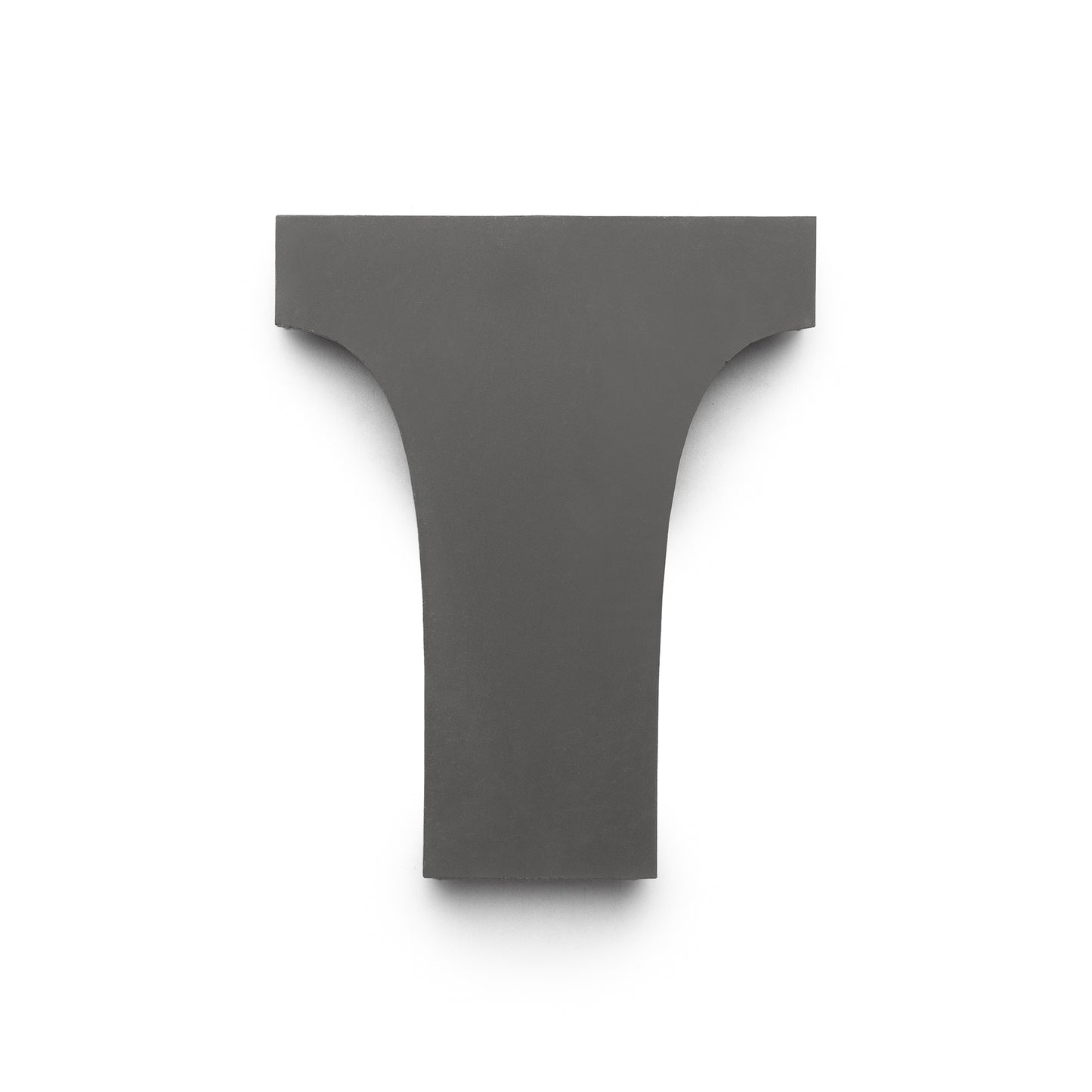 The Zia Tile Arco White + Black + Bone is a handmade, dark gray tile with curved sides in an upside-down T shape, displayed on a plain white background.