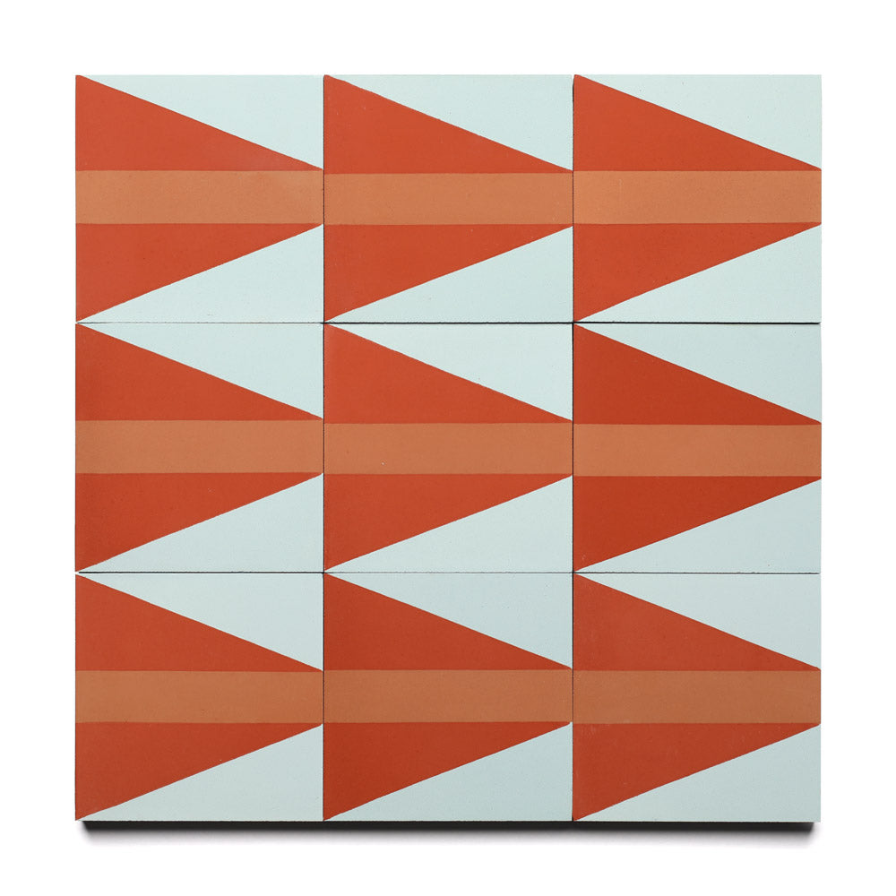 The Aviator Hailstone 4x4 by Zia Tile showcases red-orange triangles and horizontal bands on a light blue background in a three-by-three grid, forming a striking geometric motif inspired by classic handmade cement tiles.