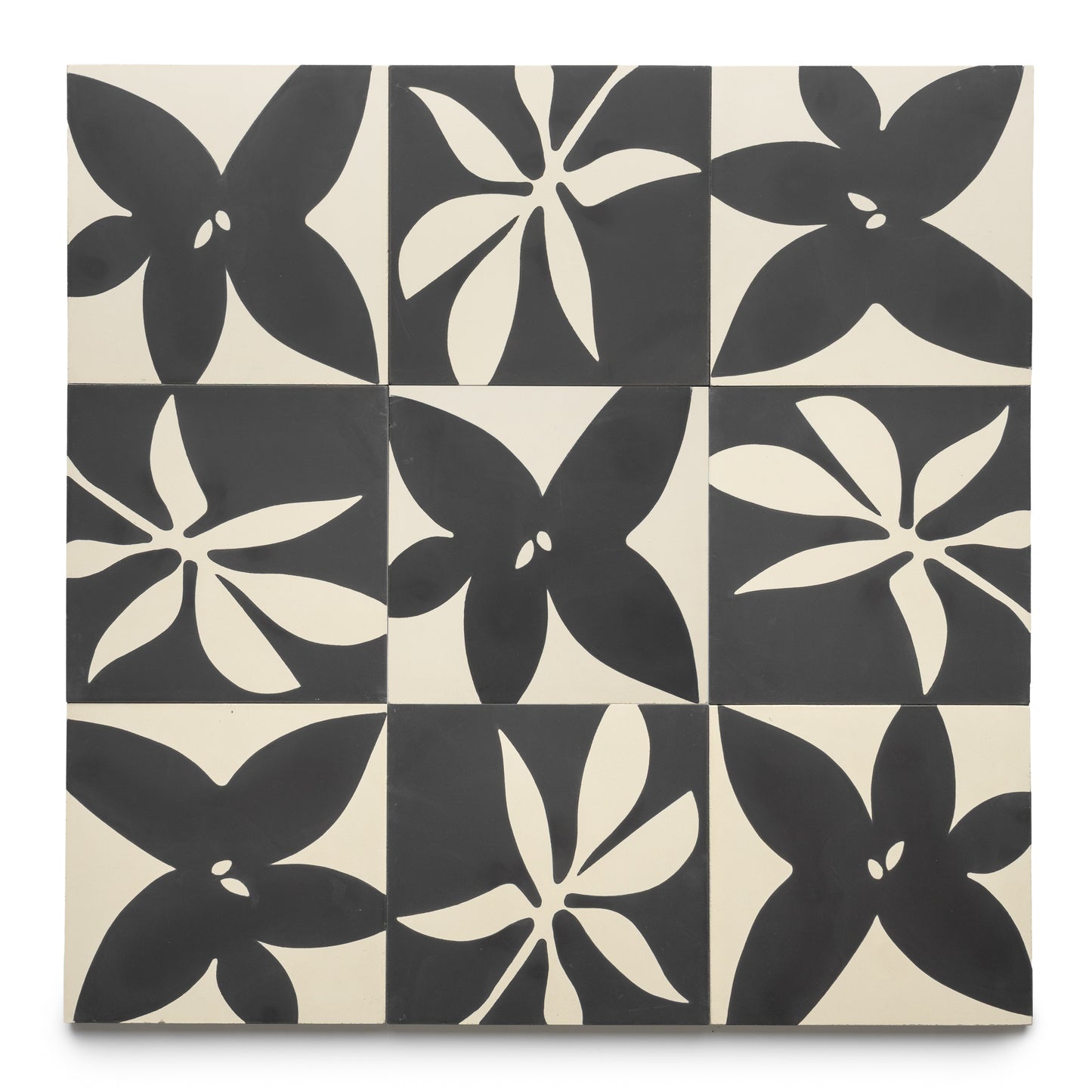 The Flora 8x8 Set Black + Bone by Zia Tile features nine square tiles in a grid, each with bold five-petal black and white floral patterns on alternating backgrounds for a striking geometric style.