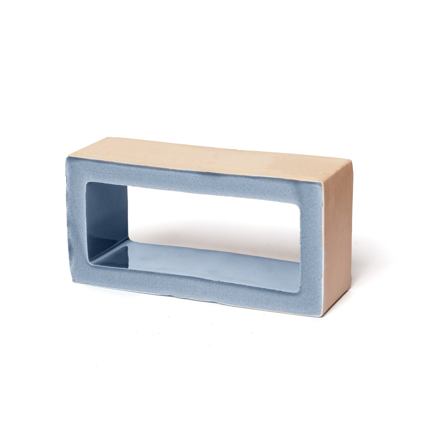 The Block + Mercury tile by Zia Tile is a rectangular ceramic piece with a beige exterior, smooth light blue interior, large hollow center, and rounded edges, shown against a white background.