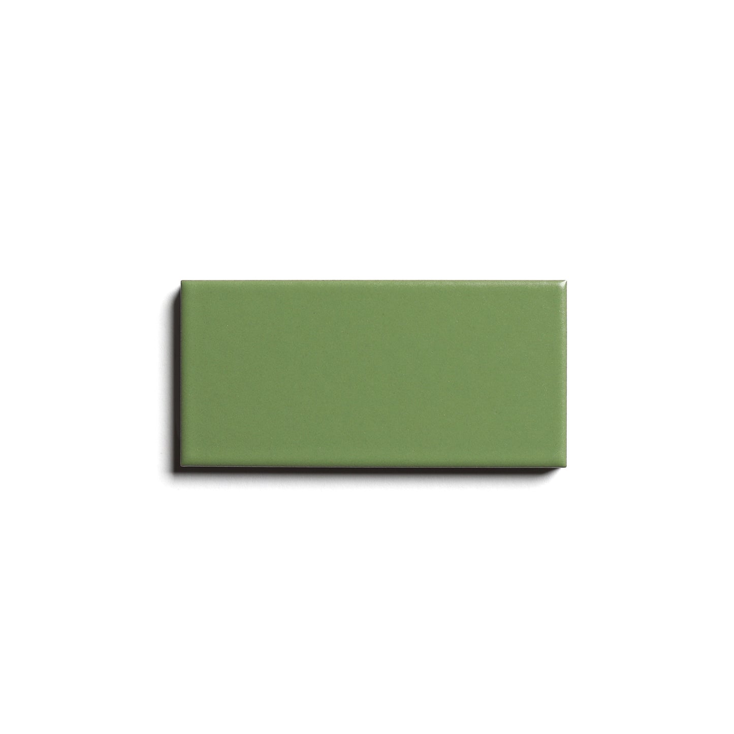 A single Bonsai 2x4 rectangular green architectural grade ceramic tile from Zia Tile with a glossy finish, shown against a plain white background with a subtle shadow on the left side.