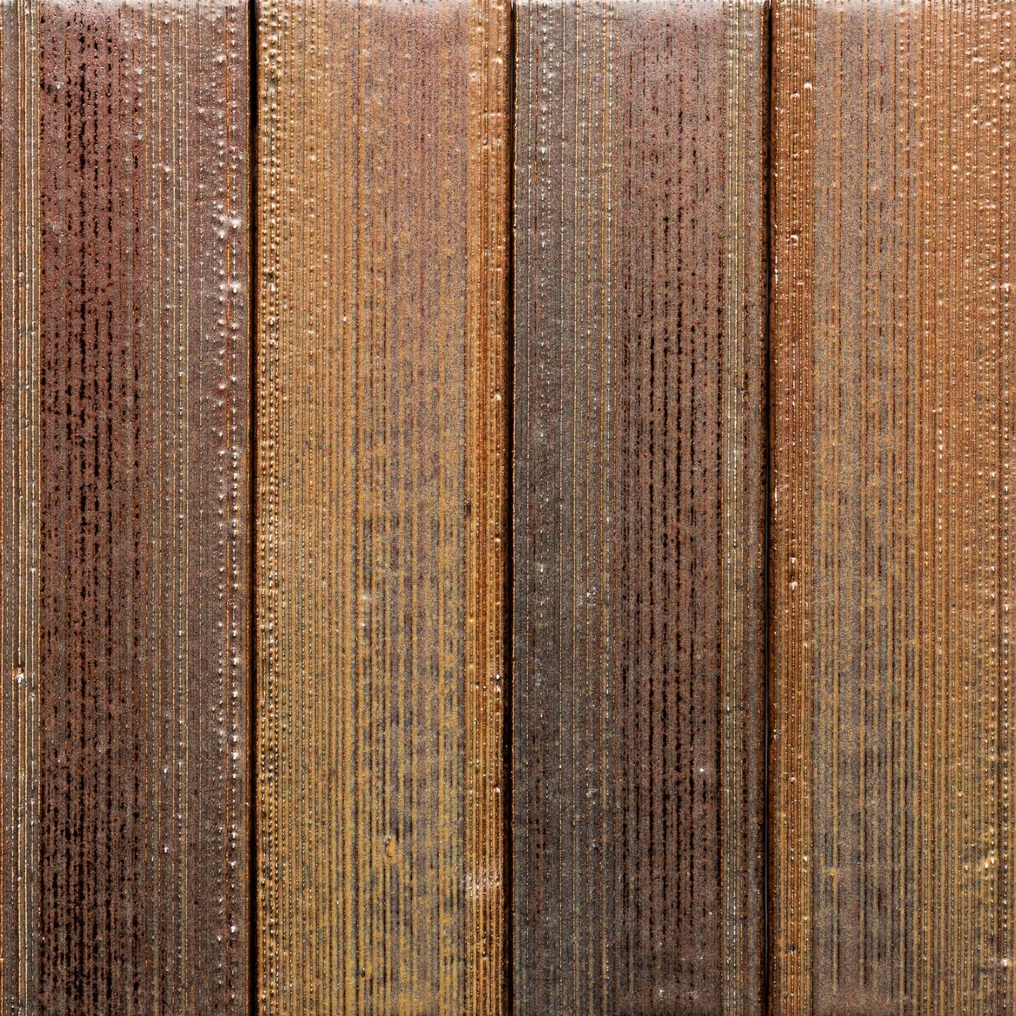 Close-up of four vertical Buckeye + Etched planks by Zia Tile, showcasing a weathered brown and tan surface with fine vertical grooves and scattered water droplets.