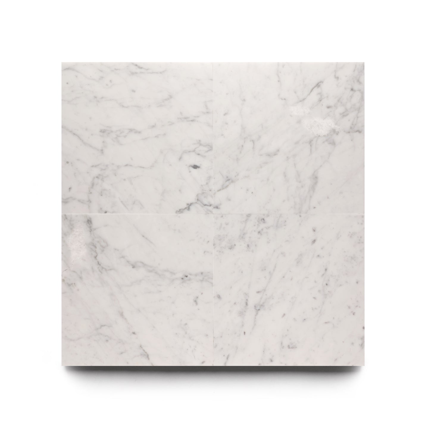 The Carrara 12x12 from Zia Tile is a square white marble slab with subtle gray veining, shown from above on a plain white background, highlighting the elegant craftsmanship of Zia Tile.