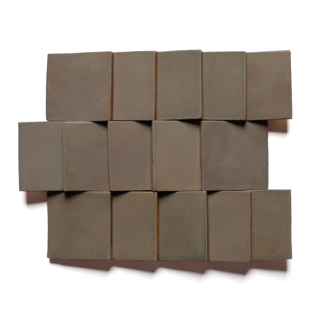 Fifteen handmade Condesa 4x4 terra cotta tiles by Zia Tile, arranged geometrically with natural overlap and slight unevenness, displayed on a white background.