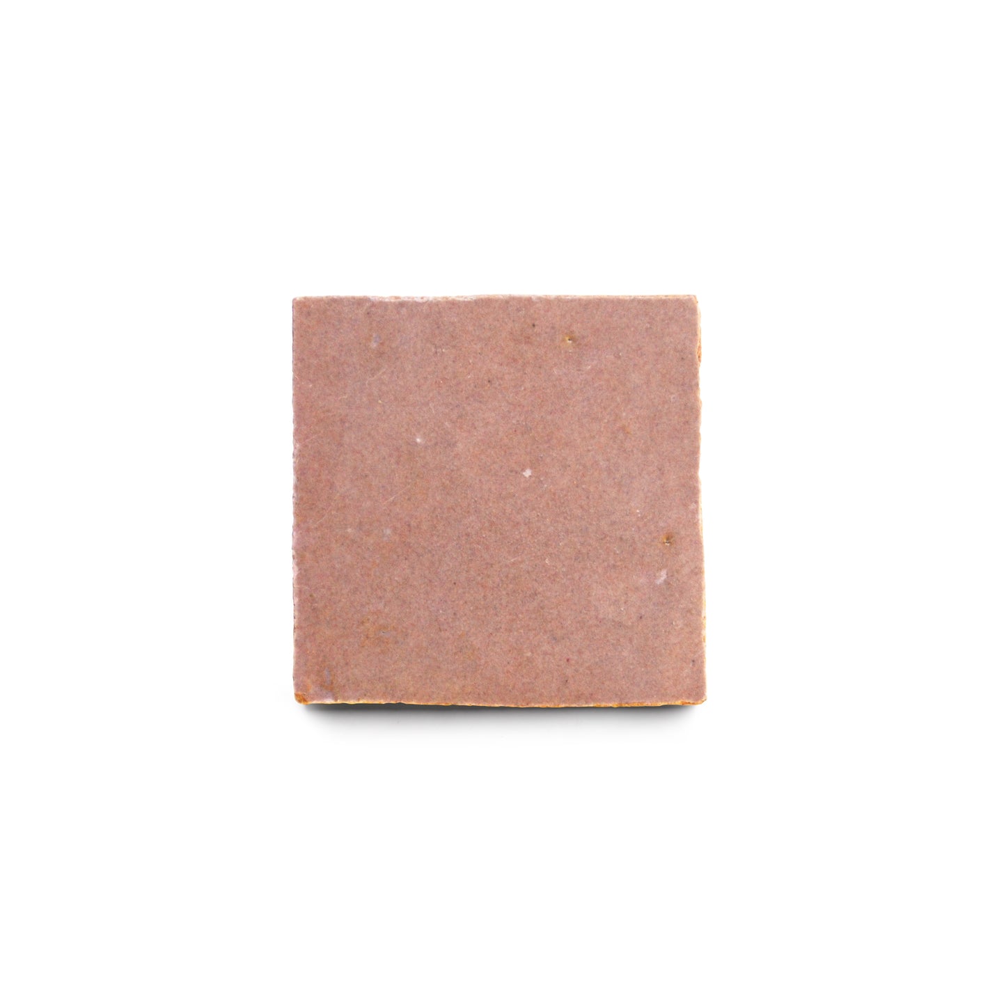 A square bar of light brown soap with a smooth surface, centered on white, evokes the warm hues of Zia Tile’s Desert Bloom 2x2.