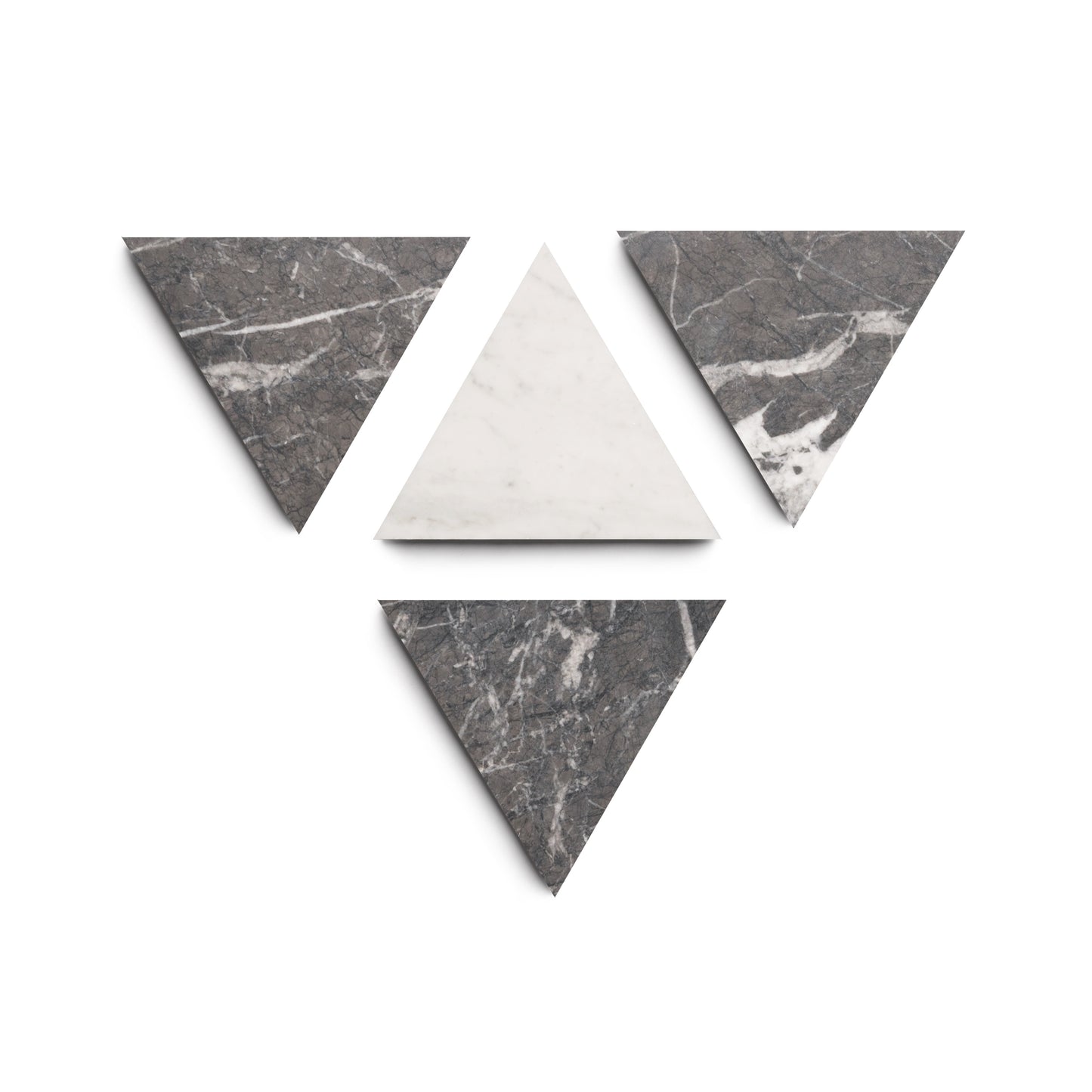 Five artisan marble triangles—four Grigio Carnico (dark gray with white veins) and one Carrara (solid white)—are arranged on a white background in an upside-down triangle, highlighting the Isola collection by Zia Tile.