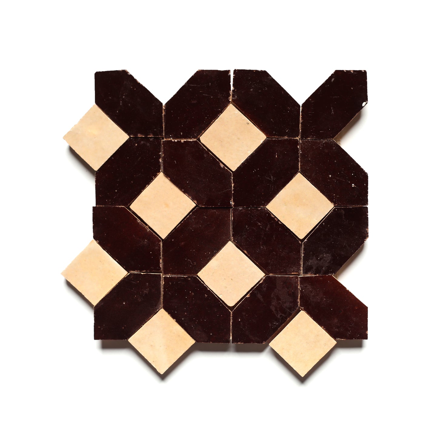 The Lattice 6 by Zia Tile features a geometric mosaic of dark brown and beige Moroccan tiles in a symmetrical, interlocking design on white—ideal for an elegant kitchen backsplash.