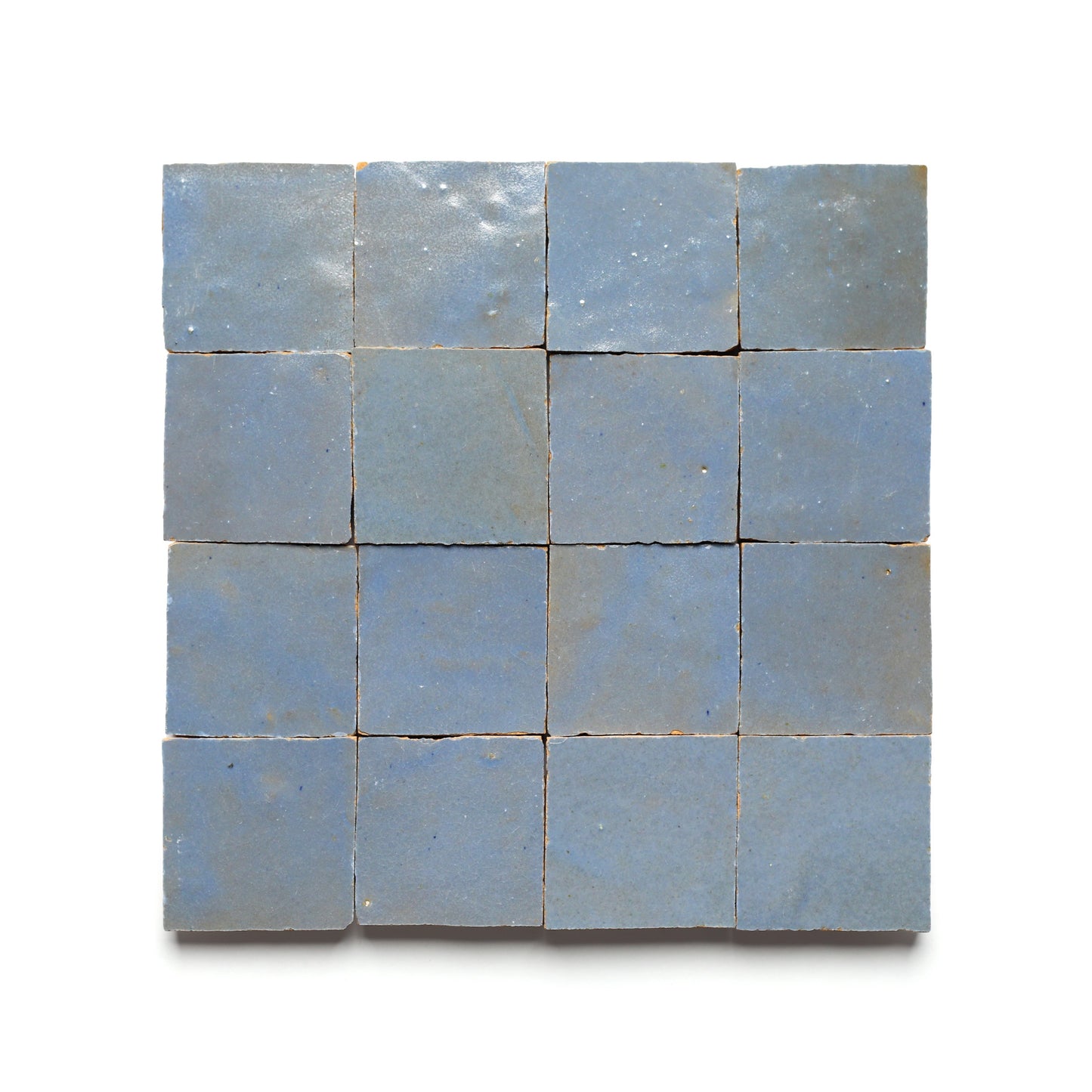 A 4x4 grid of Zia Tiles Maya Blue 2x2 sample tiles is displayed on a white background, showing subtly varied glossy surfaces and slightly rough textures.