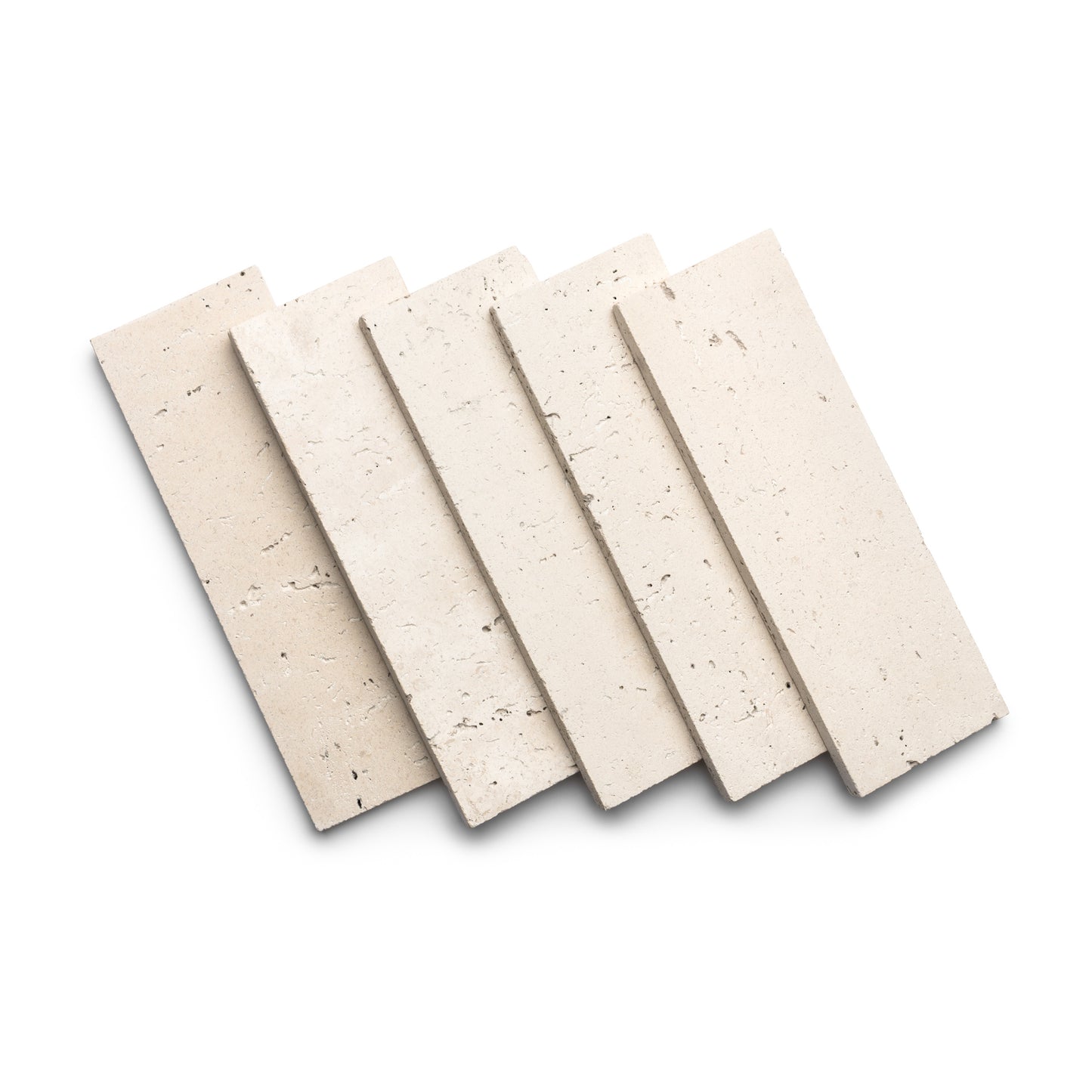 Five Zia Tile Mesa 4x12 rectangular tiles in light beige Cantera stone are fanned out and overlapping on a white background, showing their smooth surface, natural texture, and small holes typical of Mexican Cantera.