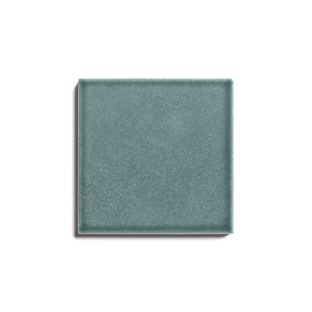 A single Nagano 4x4 teal ceramic tile by Zia Tile, architecturally graded with a smooth matte finish, is displayed on a white background with a faint shadow on the left side.