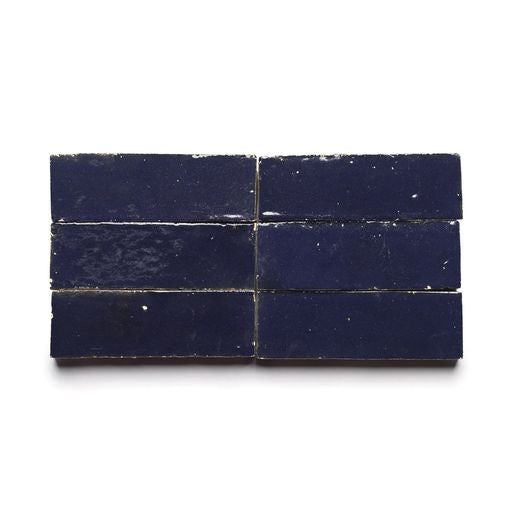 Six rectangular, glossy Night Blue 2x6 tiles are arranged in two rows of three on a white background, highlighting the classic Moroccan-inspired design and elegant finish of the Night Blue 2x6 zellige tiles.