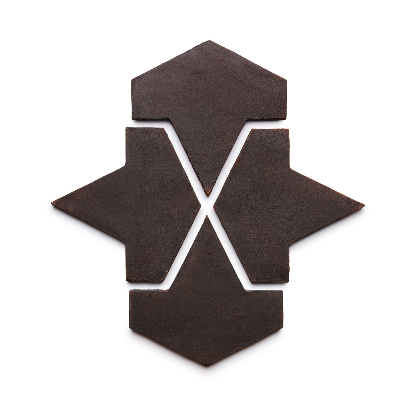 Five dark brown Big Alcazar + Oscura tiles by Zia Tile are arranged on a white background, forming a symmetrical, abstract X pattern with arrow-like points extending from the center.