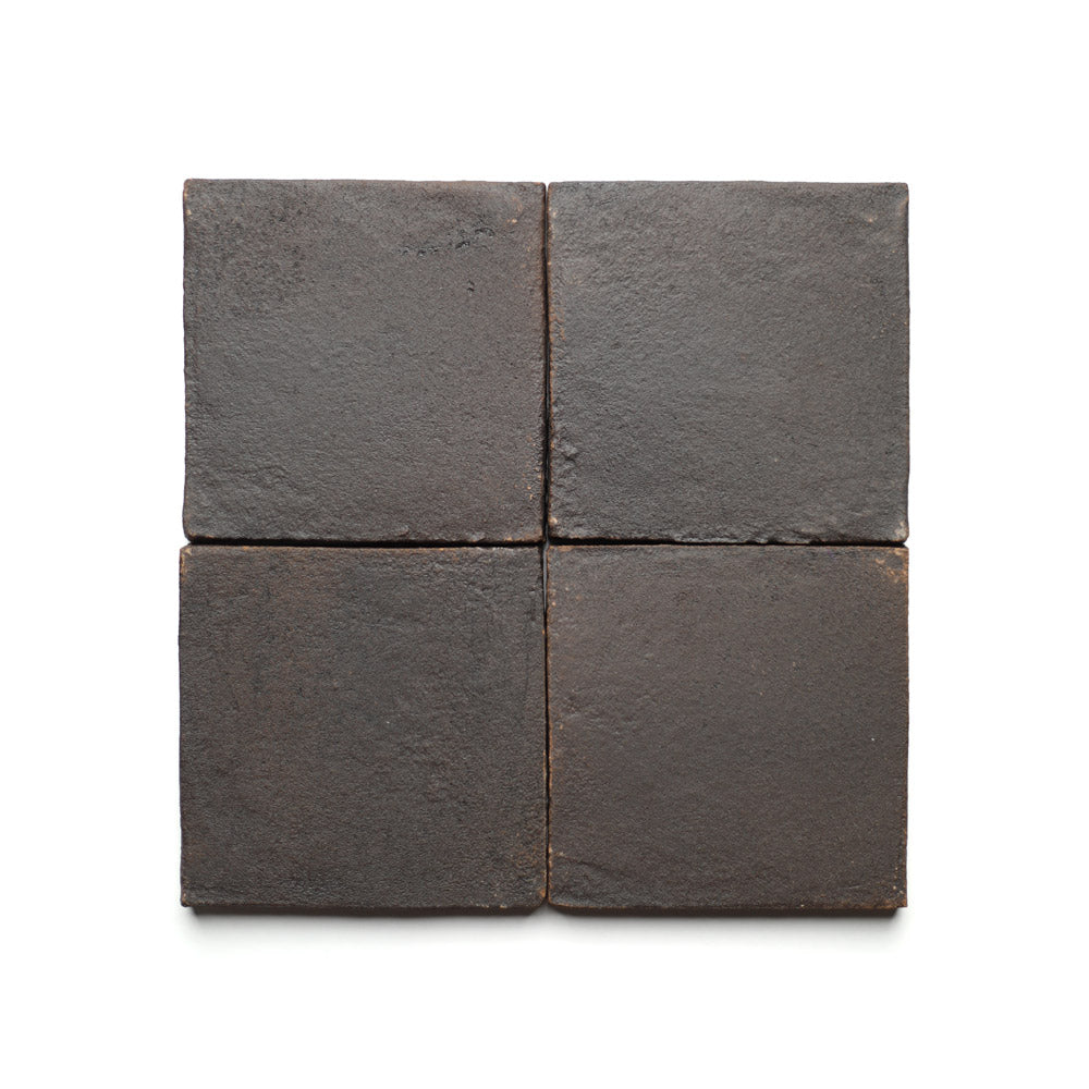 Four Zia Tile 4x4 Square + Oscura tiles are arranged in a two-by-two grid on a white background, showcasing handmade Cotto-inspired ceramic artistry with a rich dark brown color and textured, subtly varied surfaces.