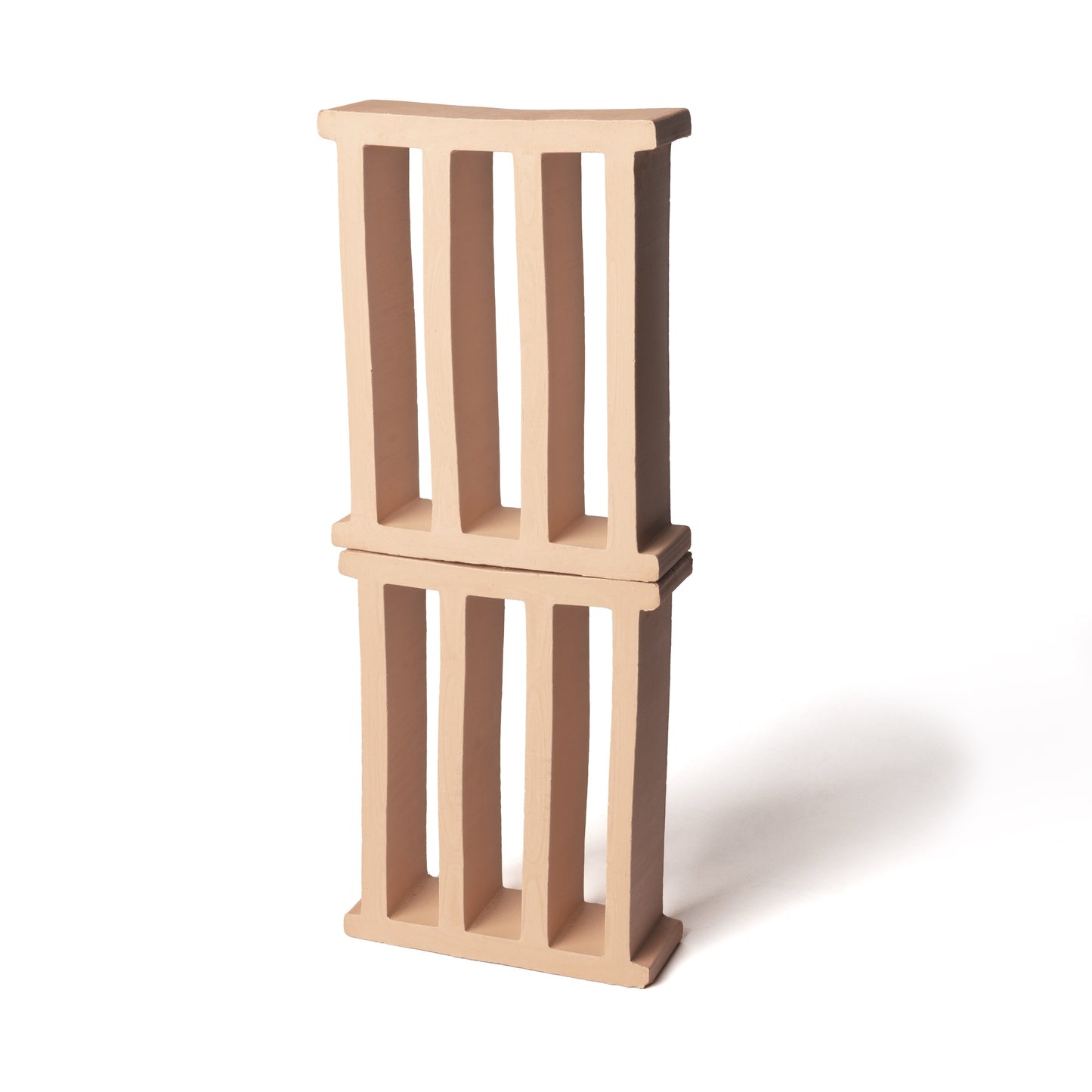 Two Pantheon + Buff Earth blocks from Zia Tile, with vertical open slats and a smooth matte finish, are stacked slightly misaligned on a plain white background. Their design and hue evoke the look of modern 3D tiles, casting soft right-side shadows.