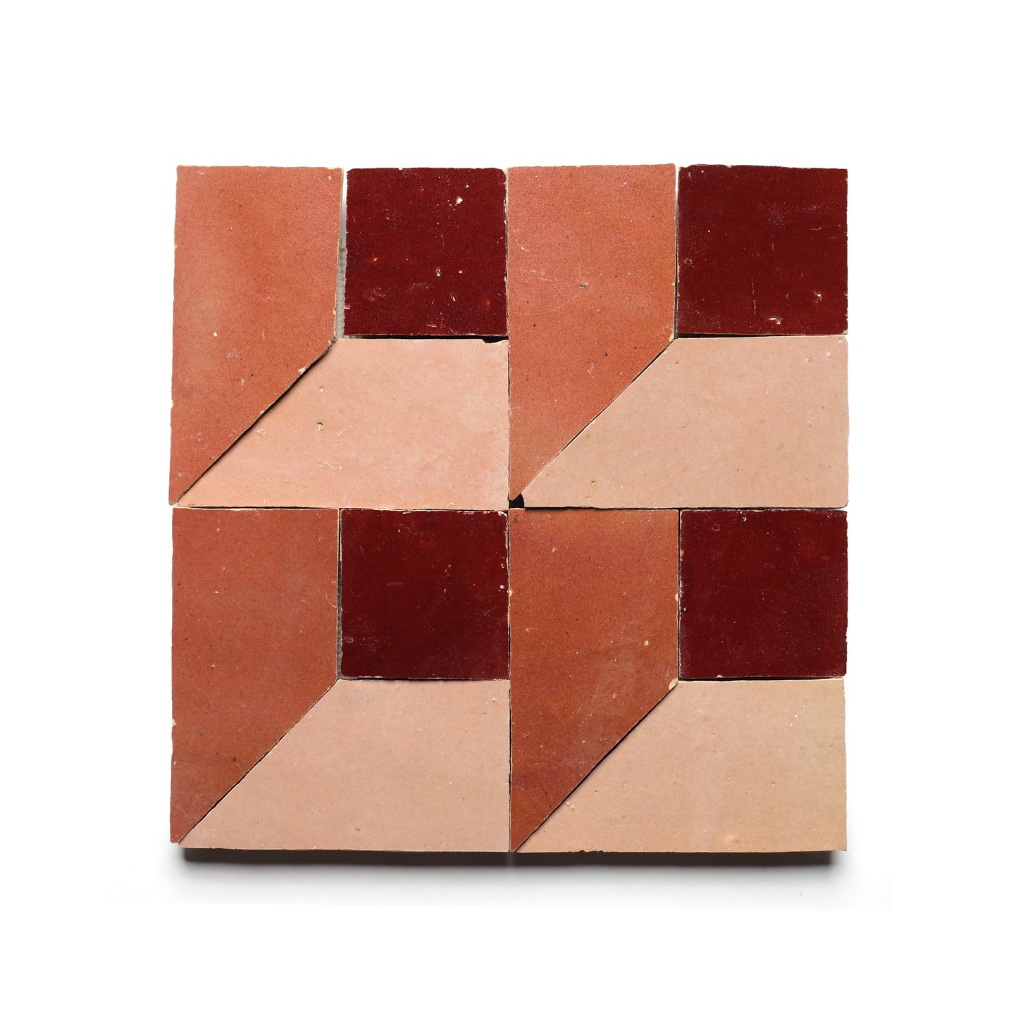 Perpetual Check 3 by Zia Tile features four square tiles forming a larger square, each with geometric patterns in dark red, terracotta, and light pink—perfect for a bold, Moroccan-inspired kitchen backsplash.