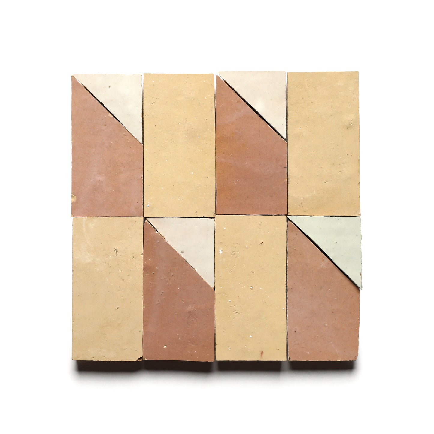 Six Radian Offset 2 tiles by Zia Tile are arranged in two rows of three. Each handcrafted tile features a light diagonal section for a geometric Moroccan-inspired pattern in pink, beige, and cream on a white background.