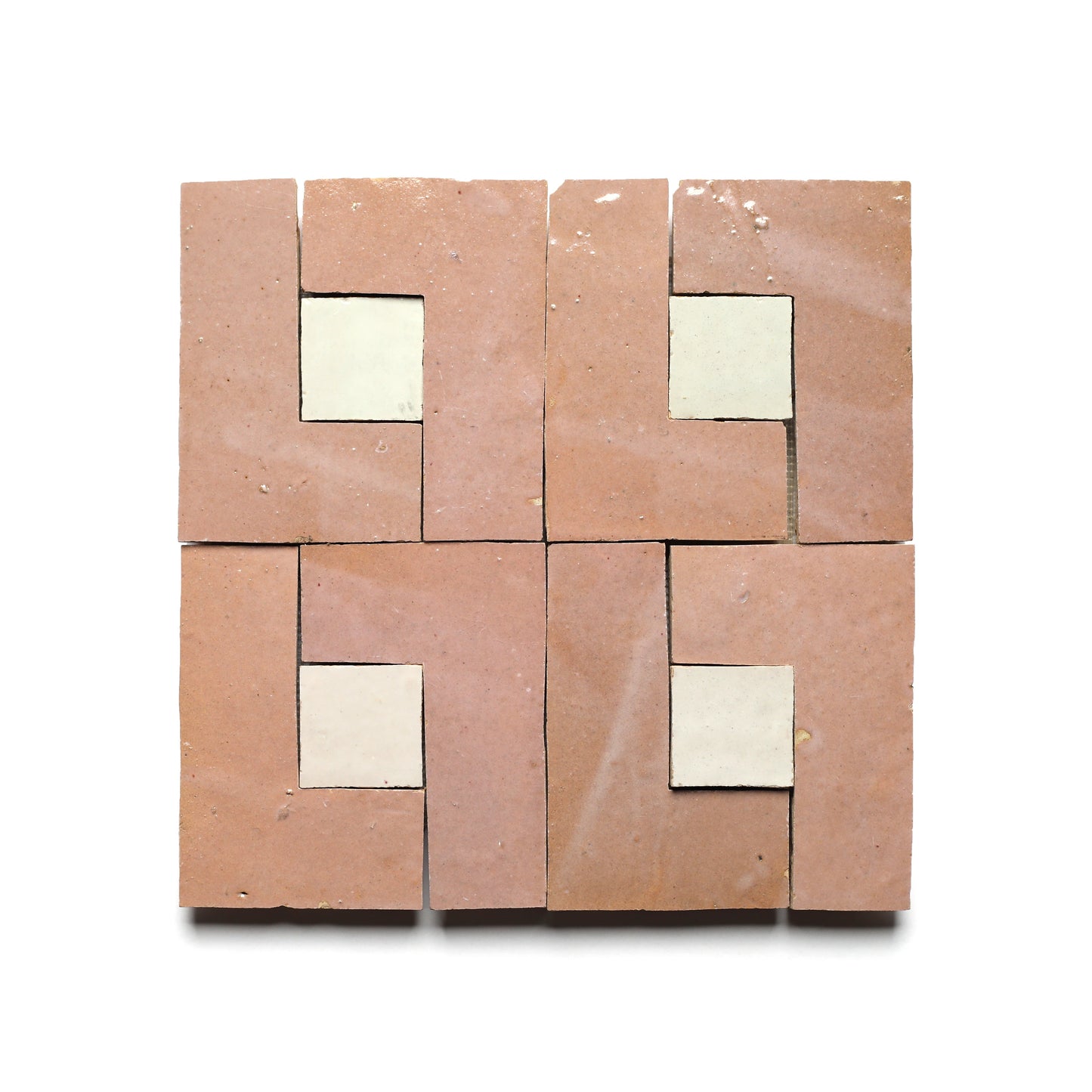 Four Zia Tile Rubric 3 tiles, crafted with L-shaped pinkish-brown pieces framing a cream square, are arranged in a 2x2 grid on white, highlighting exquisite Moroccan-inspired craftsmanship.