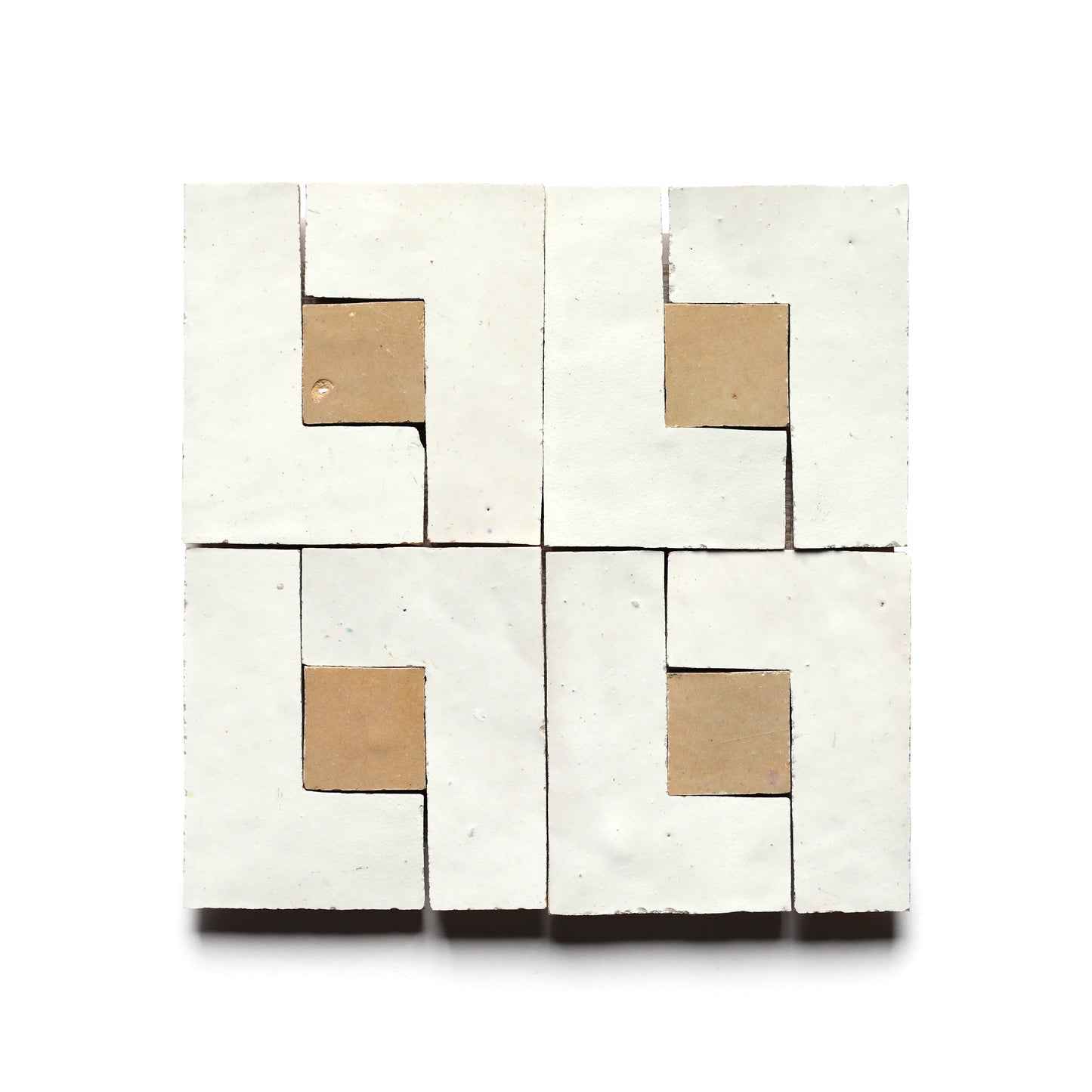 Rubric 6 by Zia Tile features four square tiles arranged in a grid, each with white and beige geometric shapes forming a symmetrical, abstract Moroccan pattern—ideal for a stylish kitchen backsplash.