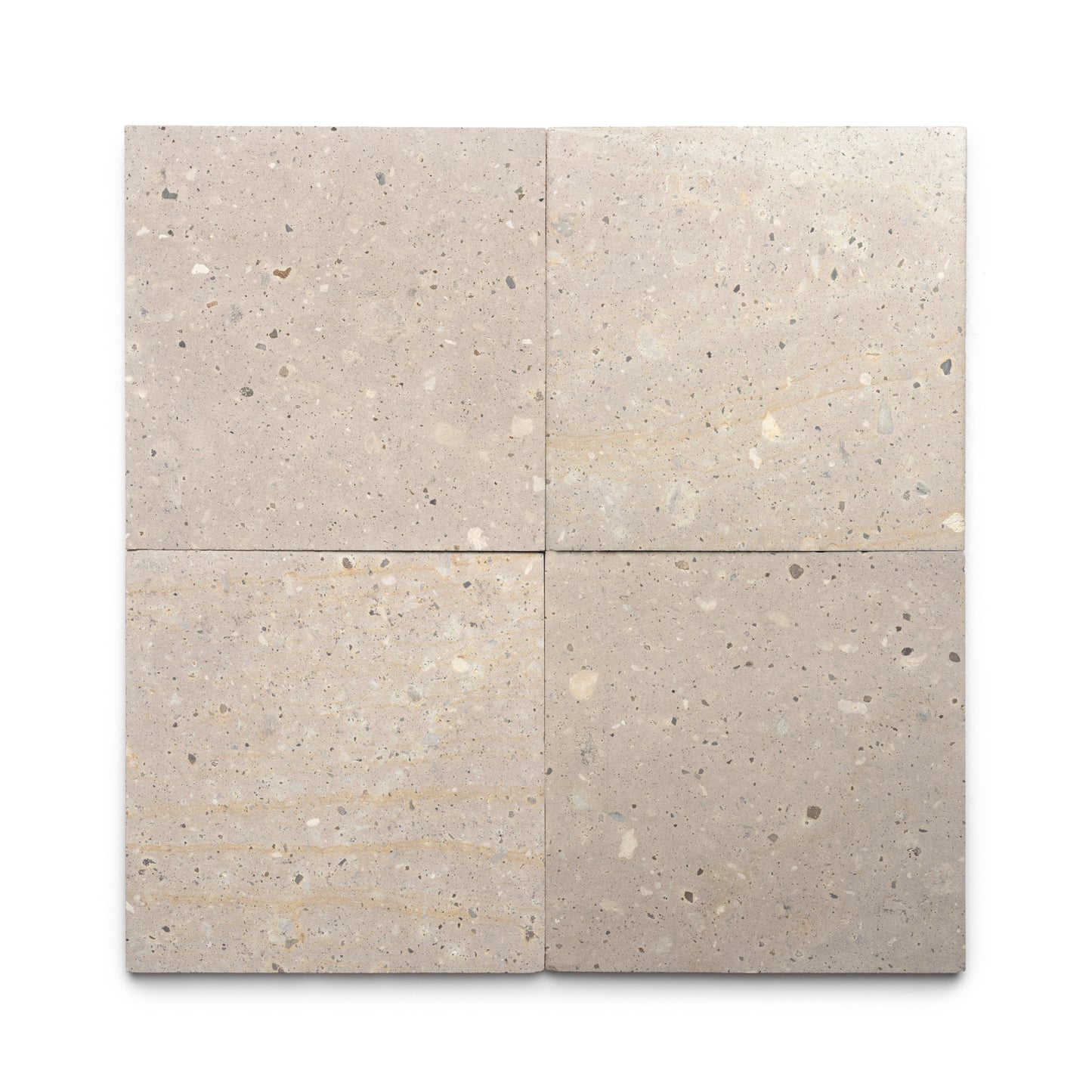 Four Sierra 12x12 tiles by Zia Tile, in square beige terrazzo with subtle speckles and natural stone variations inspired by Mexican Cantera stone, are arranged in a two-by-two grid on a white background.