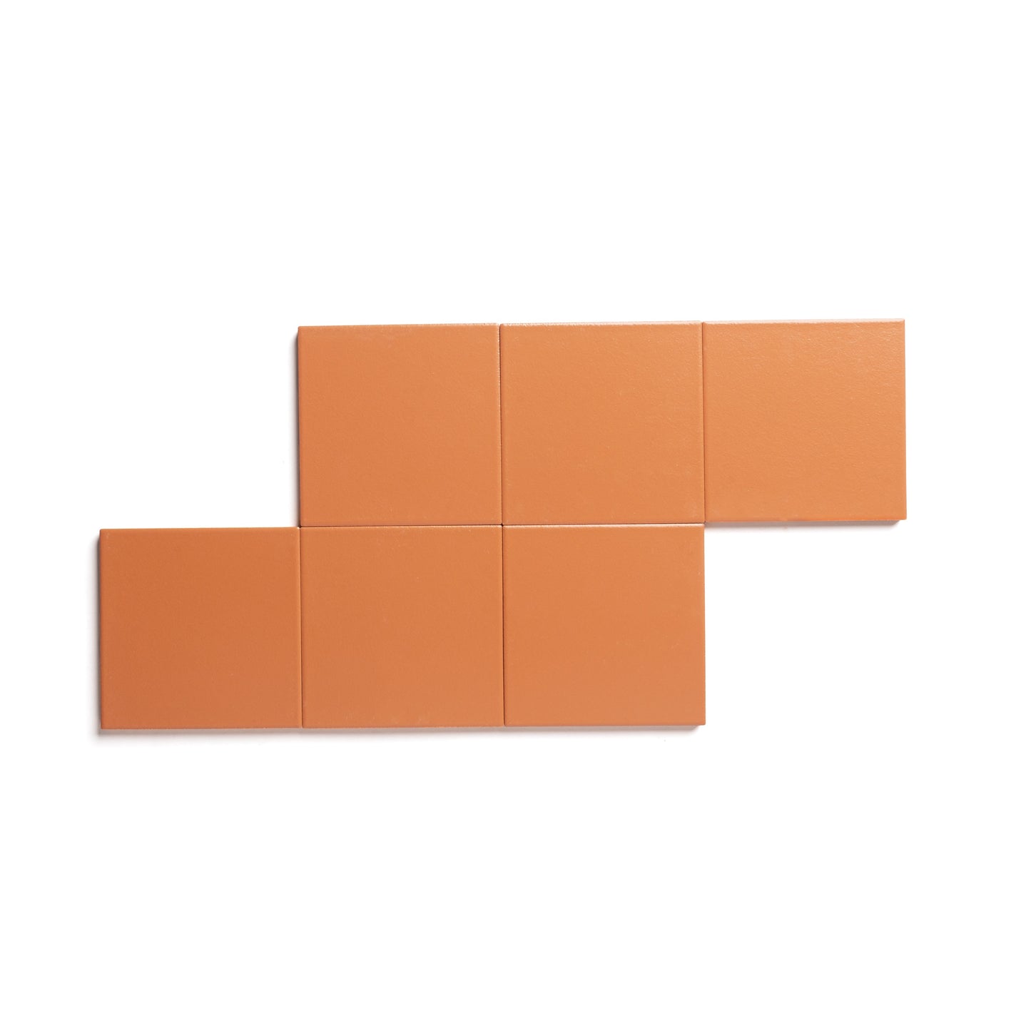 Six Tangelo 4x4 tiles by Zia Tile are arranged in two rows on a white background: three matte orange ceramics aligned left on top, three aligned right on the bottom, creating a stepped effect.