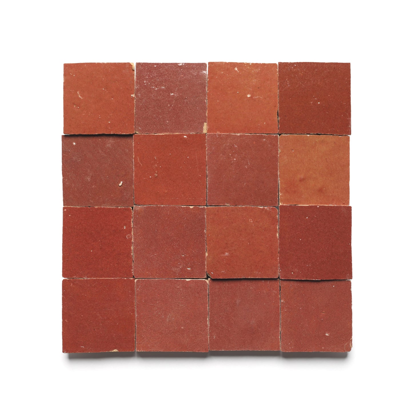 Sixteen Terra Rosa 2x2 red cement tiles by Zia Tile are arranged in a 4x4 grid on a white background. Each handmade tile shows subtle variations in shade and texture, highlighting their natural, rustic character. Sample product shown.