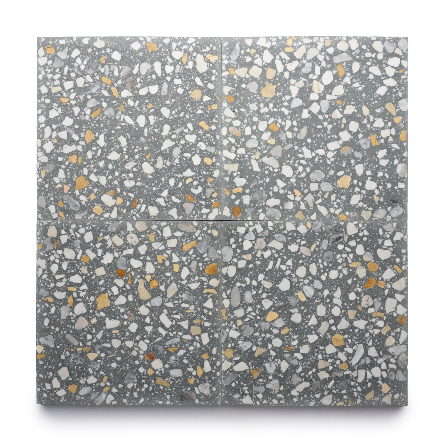 Four Andromeda 12x12 cement tiles by Zia Tile, in gray terrazzo with white, yellow, and gold stone chips, form a speckled, textured pattern that brings subtle elegance to any space.