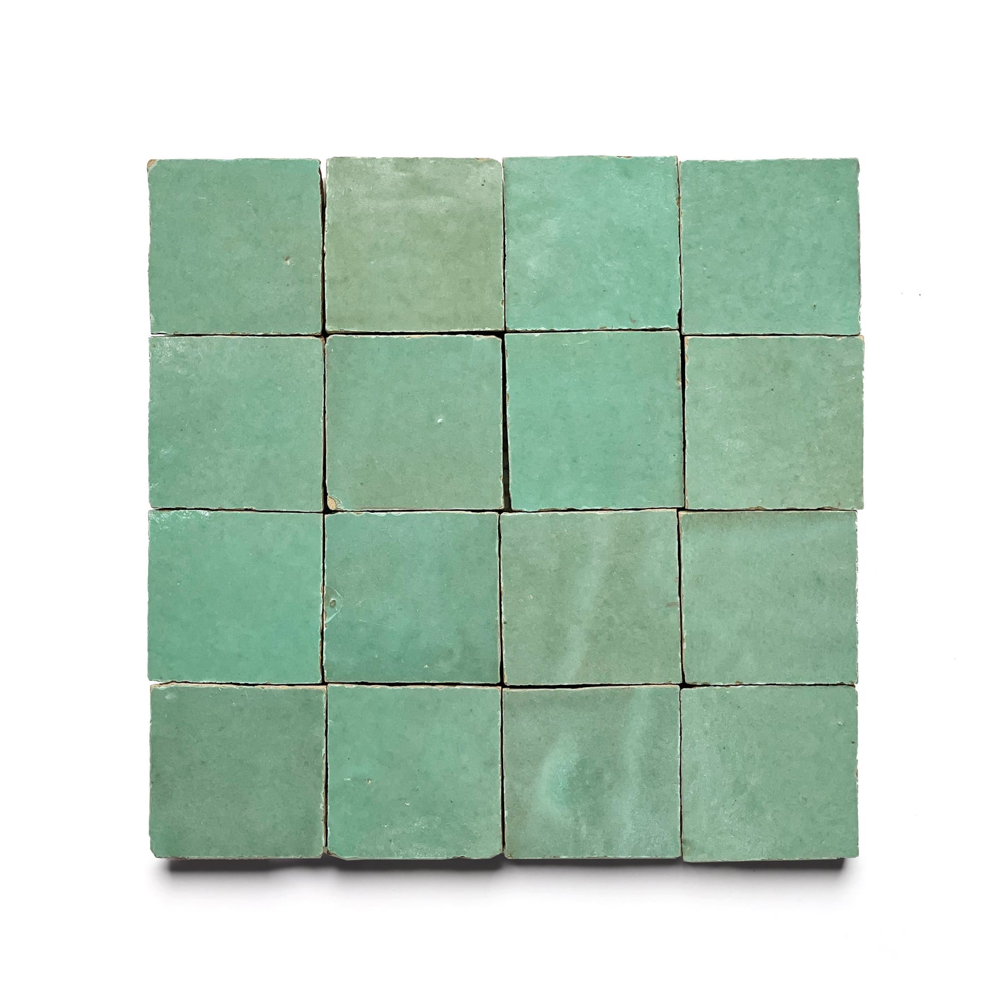 A 4x4 grid of sixteen green Tidepool 2x2 ceramic Moroccan tiles, each with subtle color variations, displayed on a white background and evoking classic zellige craftsmanship.