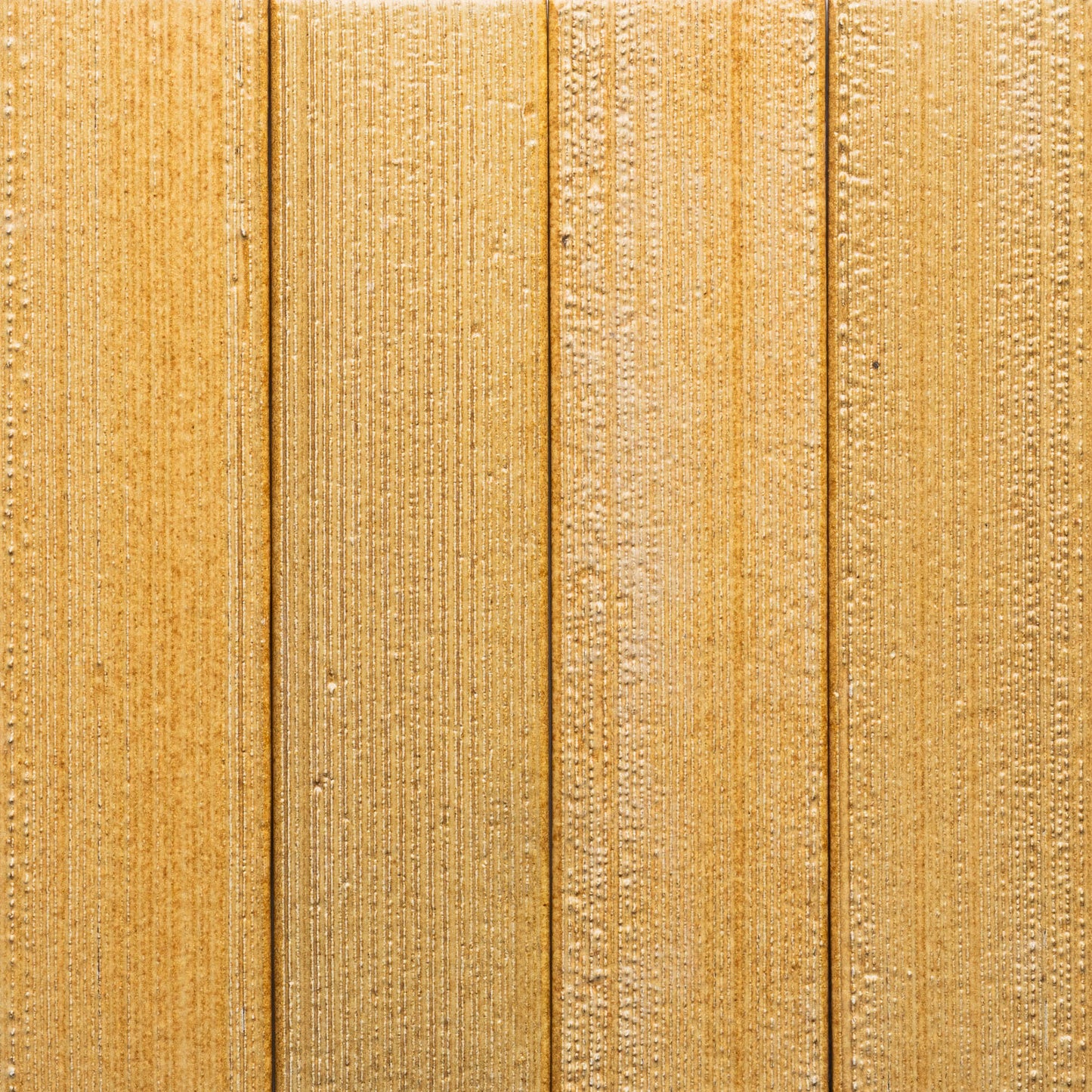 Close-up of Toast + Etched by Zia Tile, featuring four vertical light brown wooden planks with textured grain patterns and subtle lines.