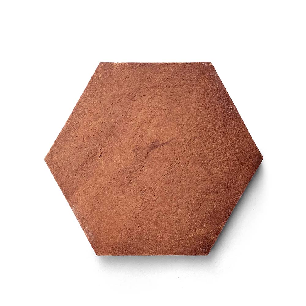 The 8x9 Hex + Red Clay, Sample from Zia Tile is a handmade hexagonal tile with a matte reddish-brown finish, shown on a white background.