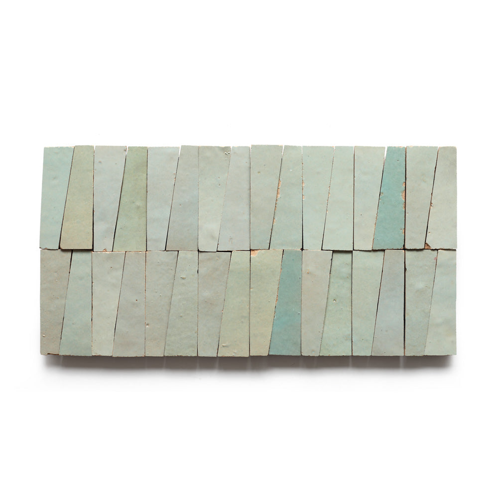 A rectangular arrangement of 20 Absinthe Trapezoid Moroccan zellige tiles in light blue and greenish tones, with uneven shapes and narrow tops, displayed in two rows on a white background.