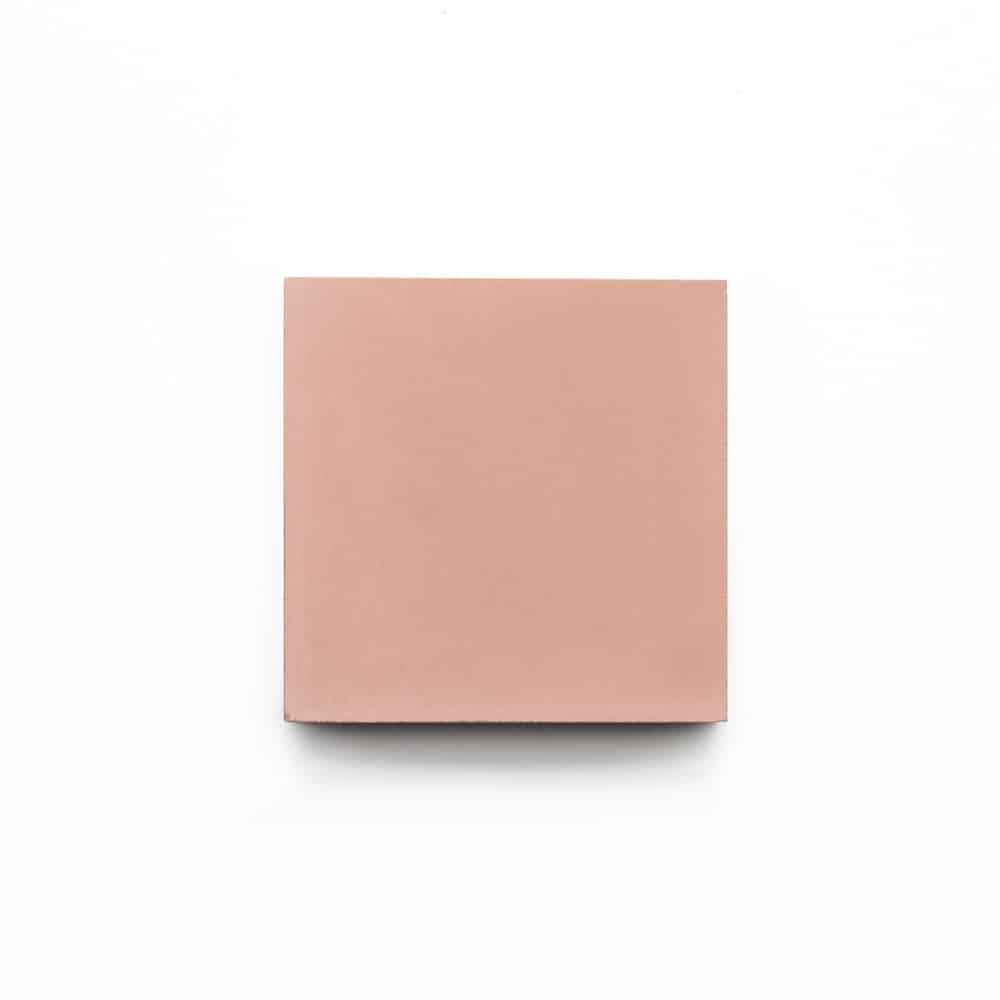 A single Bisbee Pink 4x4 tile sample by Zia Tile, featuring a matte, light pink handmade finish, is centered on a white background.