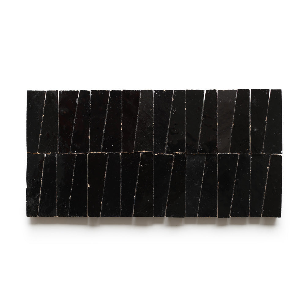 Rectangular arrangement of glossy, irregularly-shaped Carbon Black Trapezoid tiles on a white background creates a geometric, modern pattern.