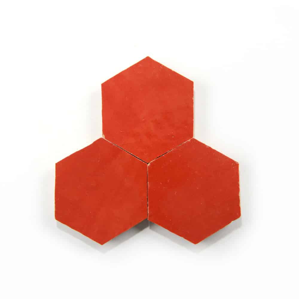 Three Cayenne Hex cement tile samples by Zia Tile are arranged with their edges touching, forming a cluster on a white background.