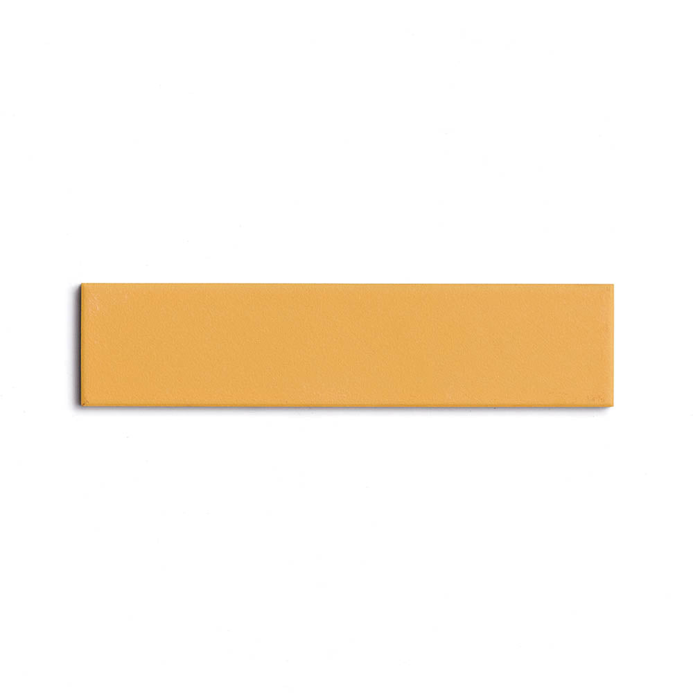 A Citron 2x8 ceramic tile by Zia Tile, featuring a rectangular shape and mustard yellow matte finish with a smooth surface, is centered on a plain white background.
