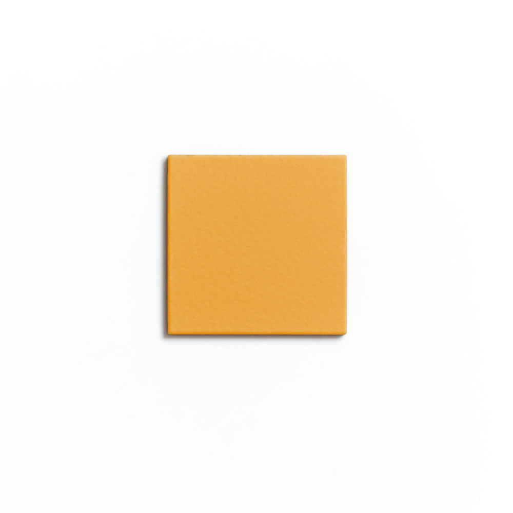 A single Citron 4x4 mustard-yellow matte ceramic tile by Zia Tile is centered on a plain white background.