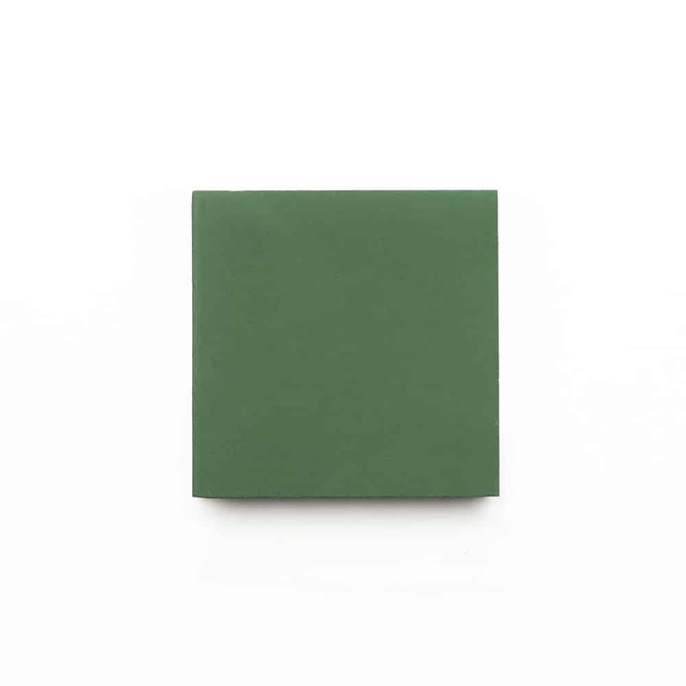 A closed, plain green book with no visible title or markings sits centered on a white background, echoing the refined simplicity of vendor-unknowns Emerald 4x4, Sample tile.