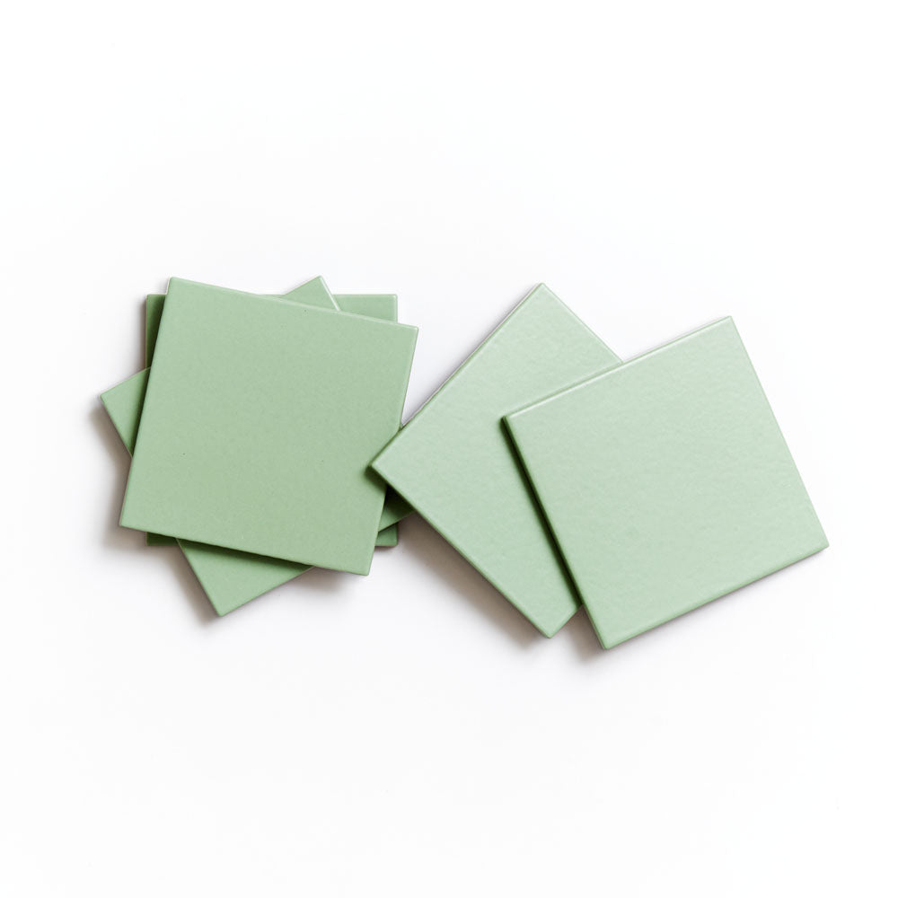 Five Eucalyptus 4x4 ceramic tiles from Zia Tile are displayed overlapping on a white background, highlighting their matte finish.