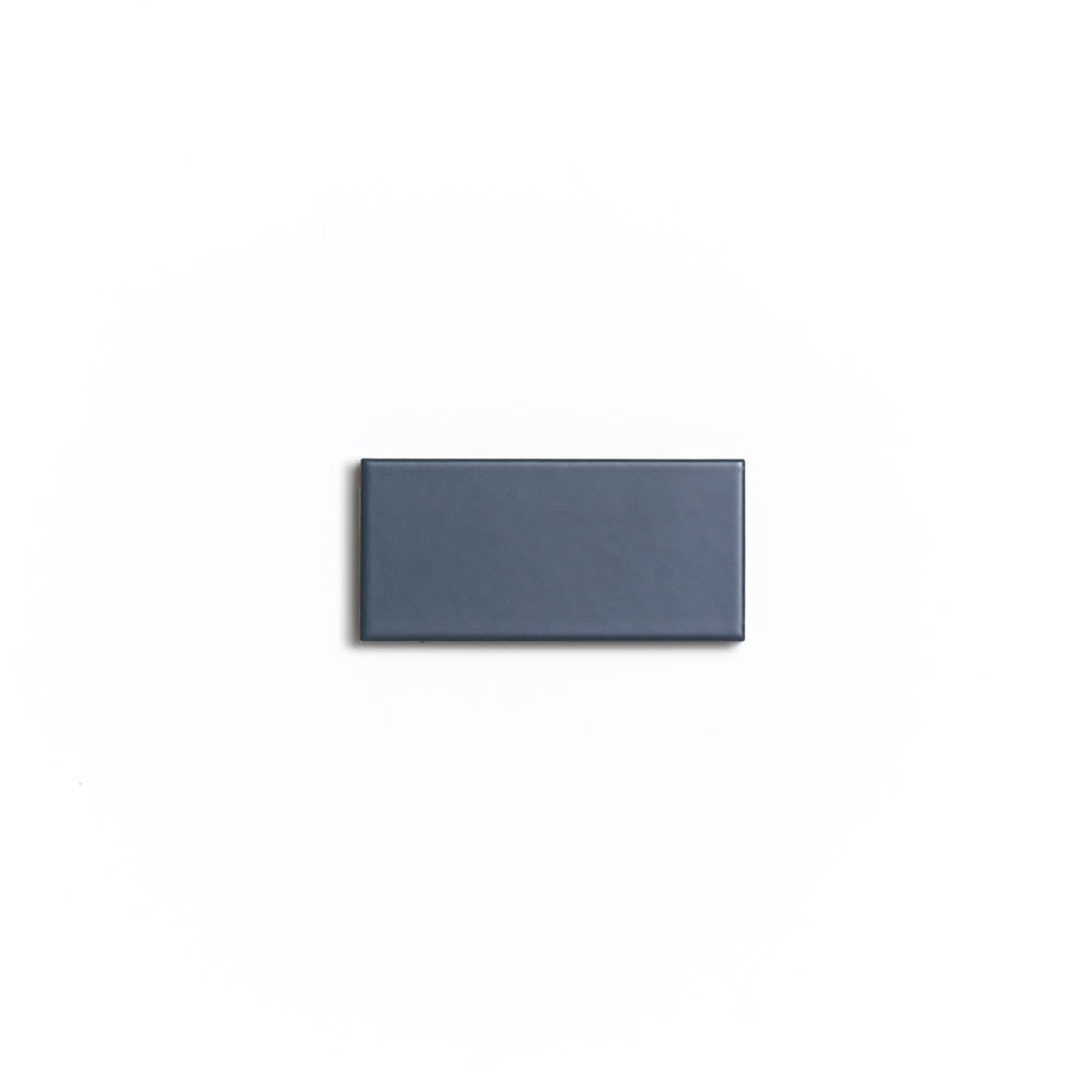 A single rectangular, solid Pacific Blue 2x4 ceramic tile by Zia Tile is centered on a plain white background.