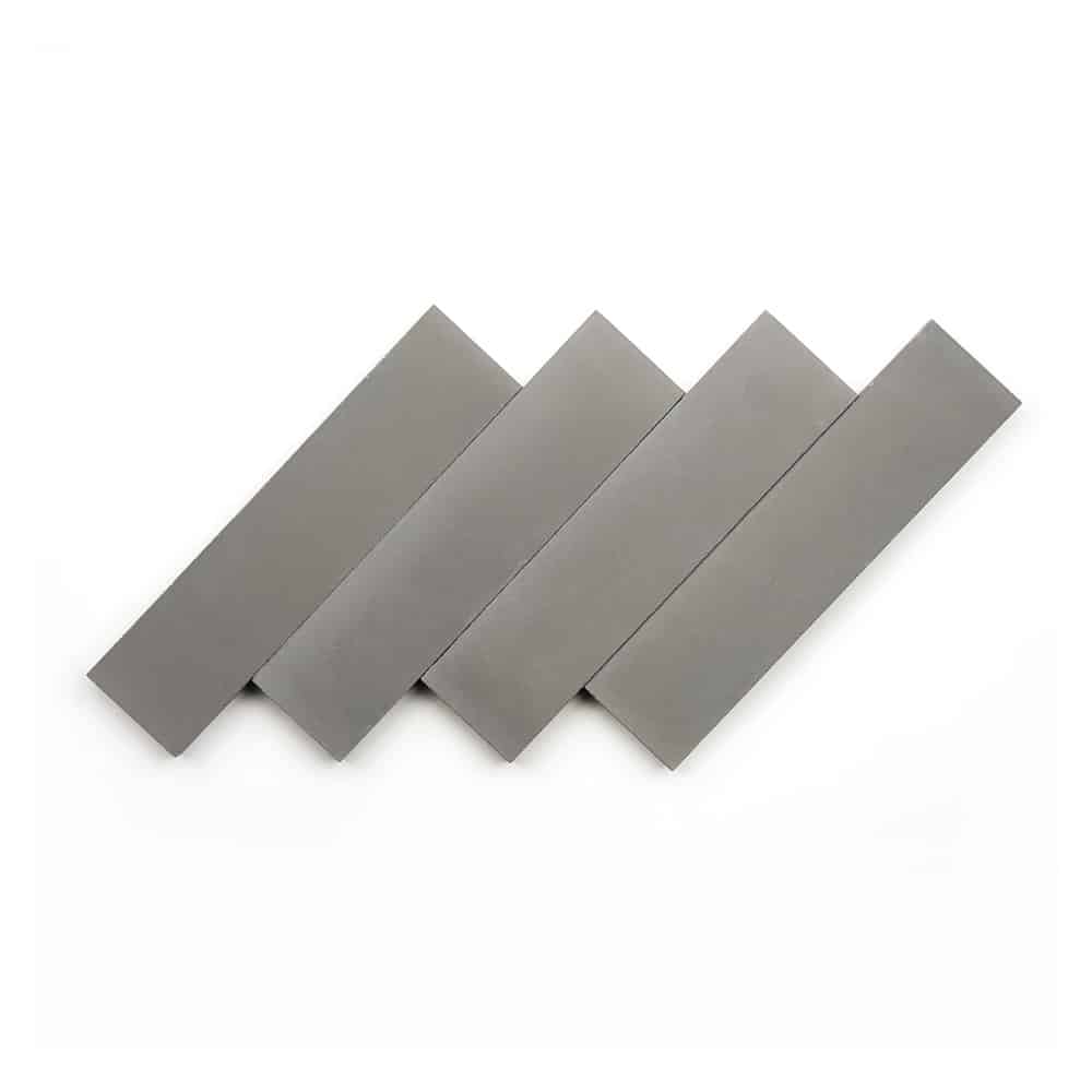 Four rectangular Pewter 2x8 subway tiles are arranged diagonally on a white background, highlighting the sleek and modern appeal of this stylish tile design.