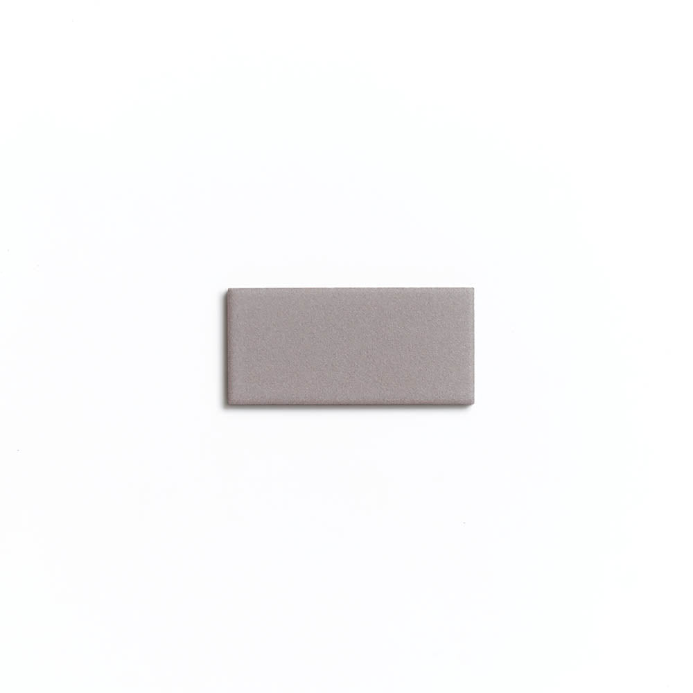A small, rectangular Portland Grey 2x4 matte ceramic tile by Zia Tile is centered on a plain white background.
