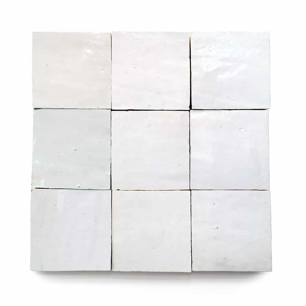 Nine Pure White 4x4 Zia Tile samples arranged in a 3x3 grid on a white background. These handmade tiles display subtle variations in texture and reflectivity, along with small surface imperfections.