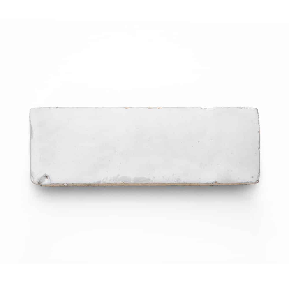 A rectangular white brick with rough edges and slight imperfections, similar to the Pure White 2x6 tile, photographed against a plain white background.