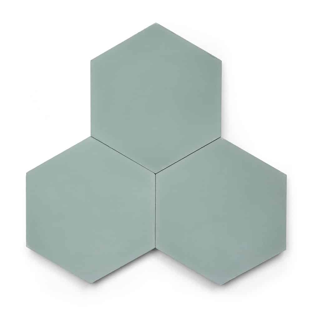 Three Sage Hex tiles in a light green-grey shade are arranged with two at the bottom and one above, creating a symmetrical pattern. Each cement tile has a smooth, matte finish.