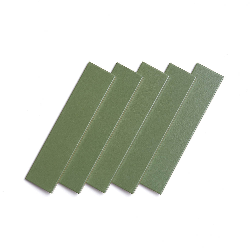 Five Sequoia 2x8 rectangular green matte ceramic tiles by Zia Tile are arranged in a slightly fanned-out pattern on a white background.