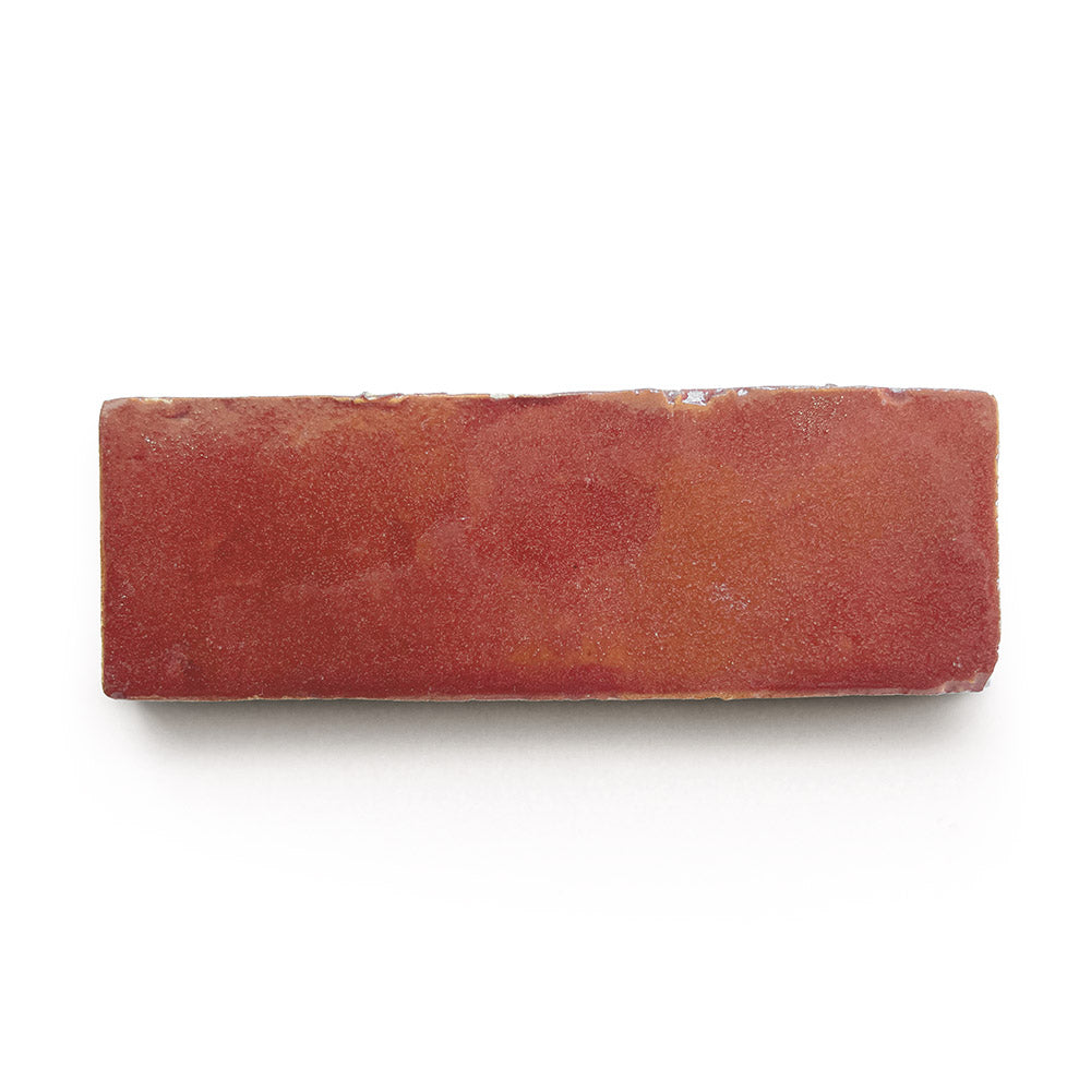 A single Terra Rosa 2x6 rectangular red brick with a slightly rough texture, reminiscent of zellige tiles, viewed from above on a white background.