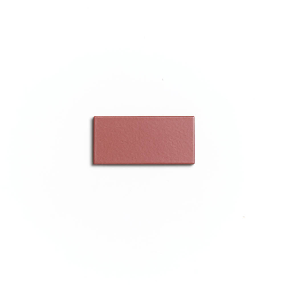 A single Wild Fig 2x4 rectangular matte ceramic tile by Zia Tile in mauve is centered on a plain white background, highlighting the elegance of architectural grade tiles for any indoor or outdoor project.