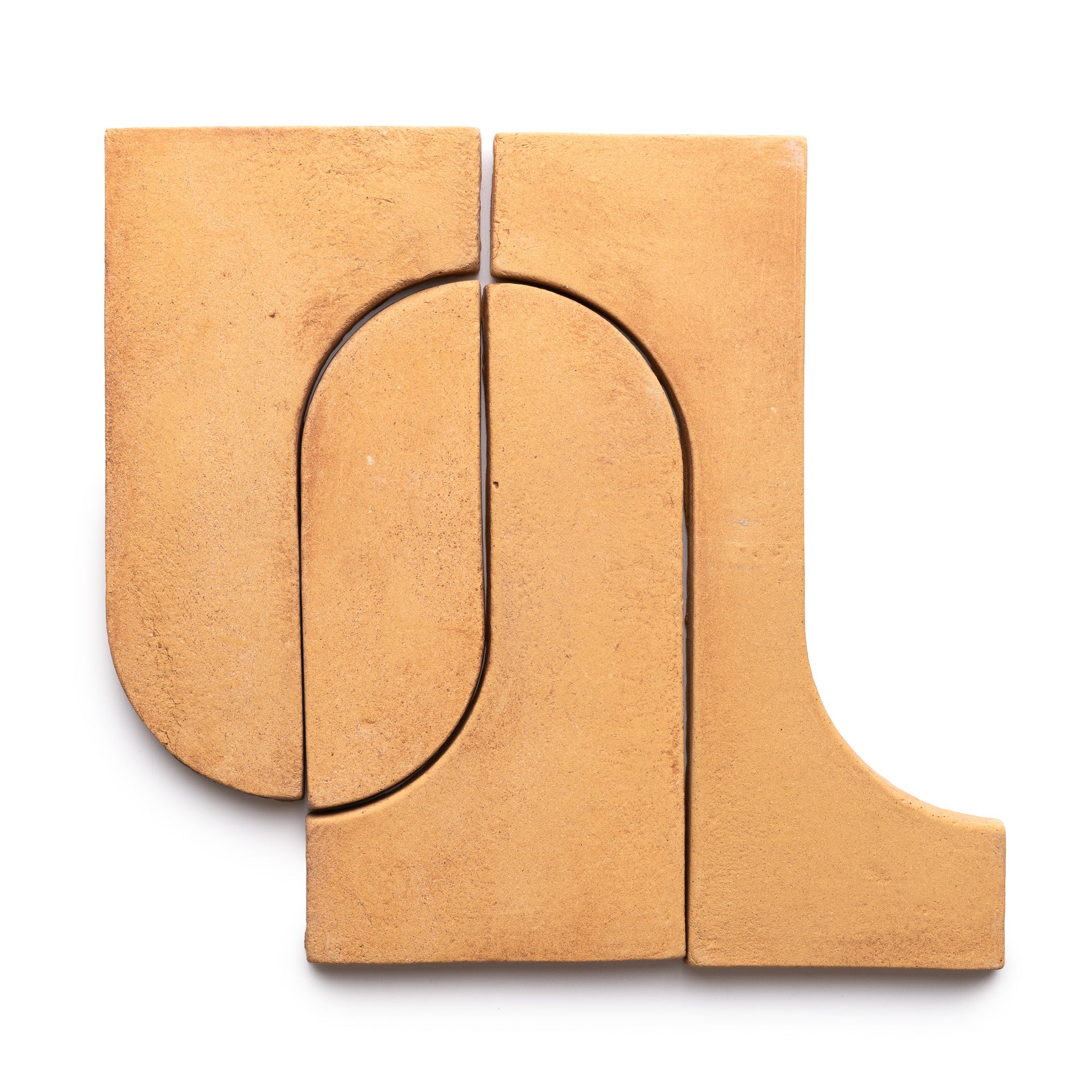 Four Durango + Adobe tan ceramic tiles by Zia Tile are arranged together on a white background, creating an abstract geometric shape with both curved and straight edges.